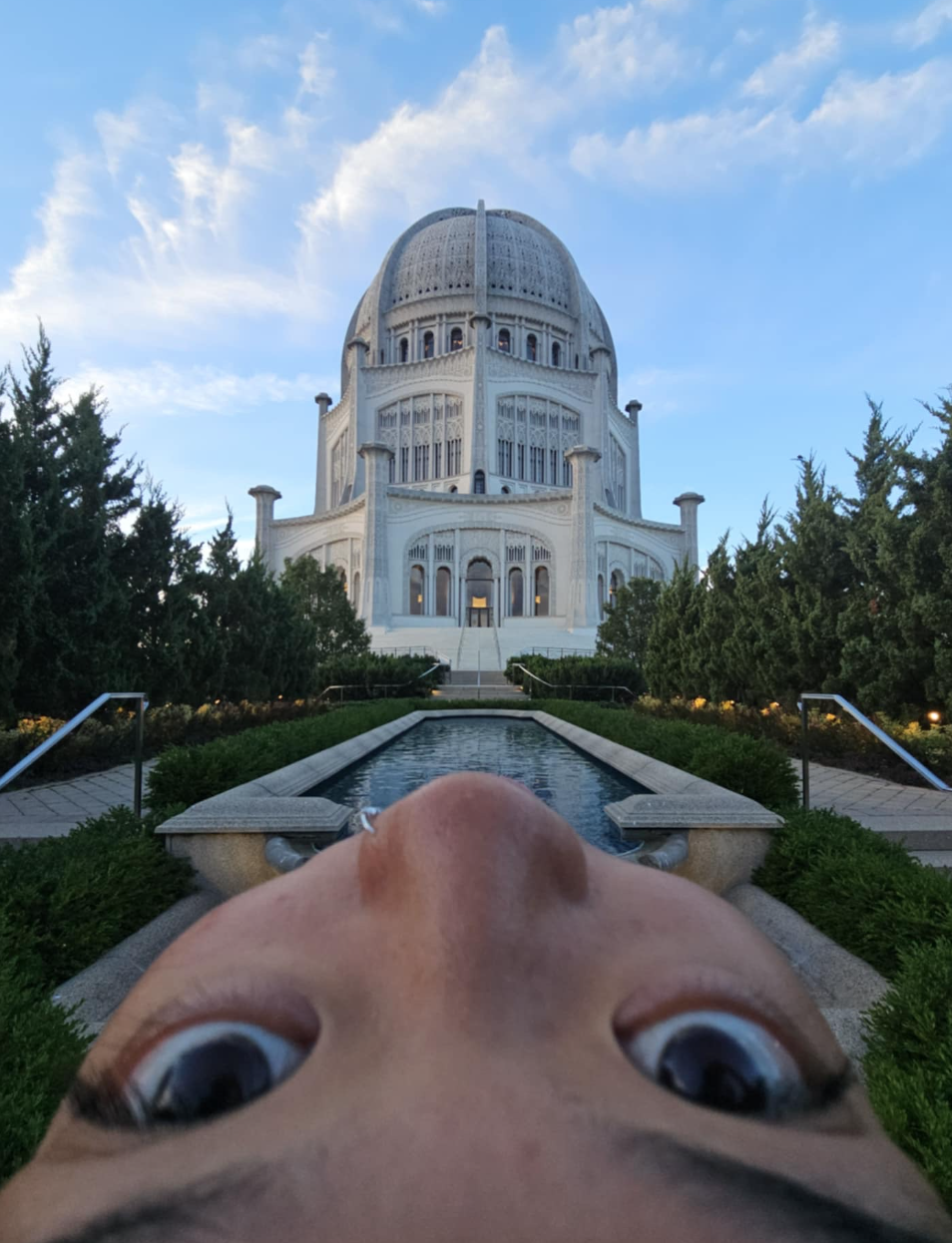 Tina in front of Bahá'í Temple of North America with her eyes upside down in front of camerahaha